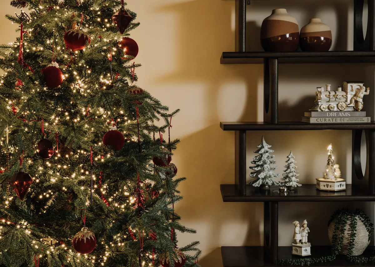A lifestyle image of the Aspen tree with red glass ornaments including tree