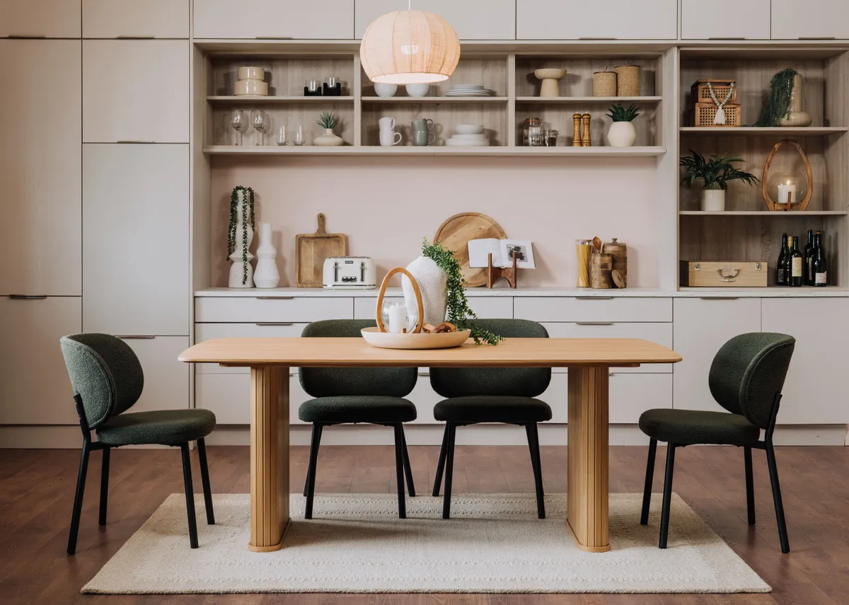 A lifestyle image of the Sovat rug in a kitchen setting under the Nola oak table with swan green chairs.