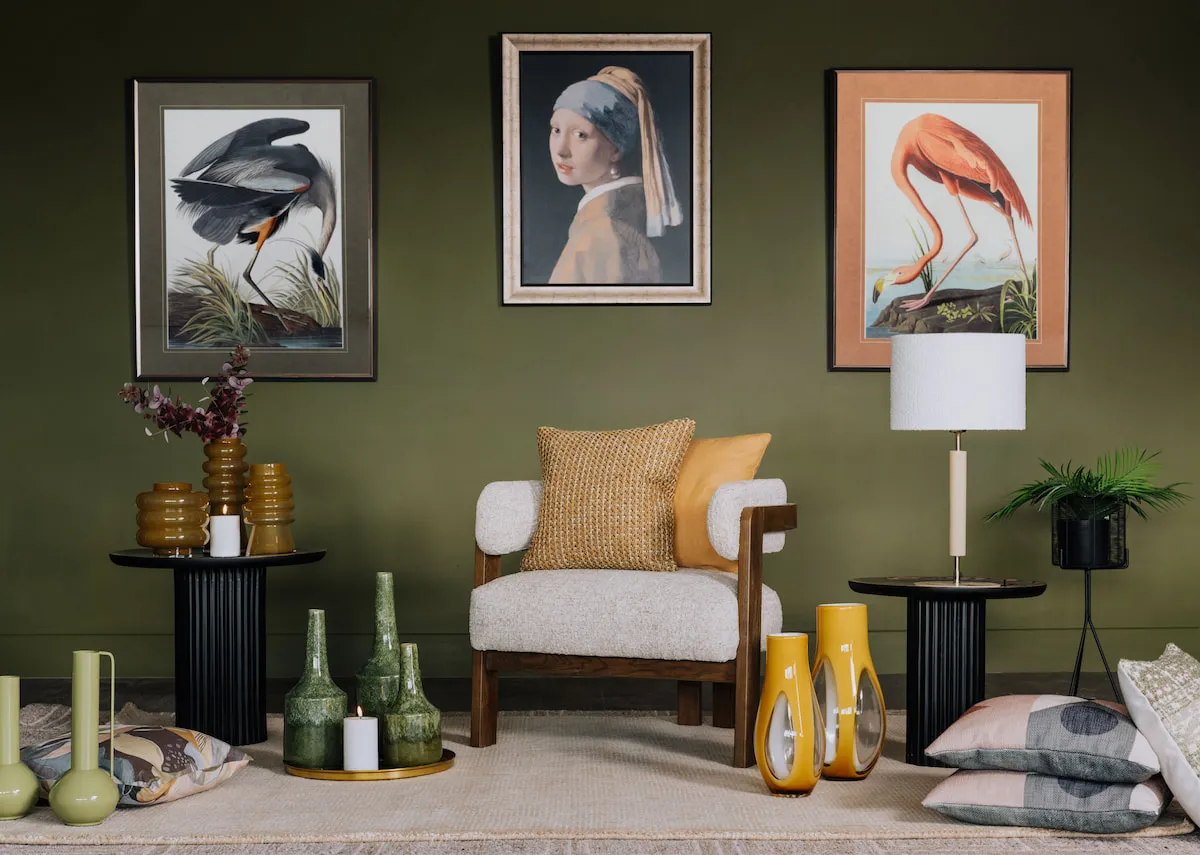 A lifestyle image of the Noma accent chair with a selection of prints and vases