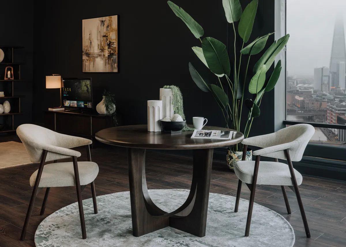 A lifestyle image of the Flow espresso dining table with 2 elk chairs on the modesto rug