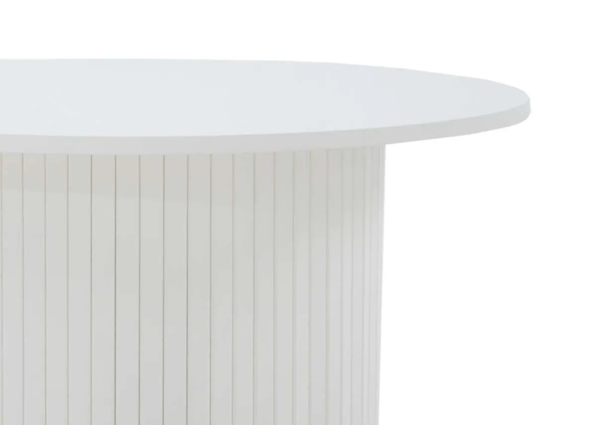 A close up view of the white oak round coffee table highlighting the smooth top and the vertical slatted texture of its cylindrical base.