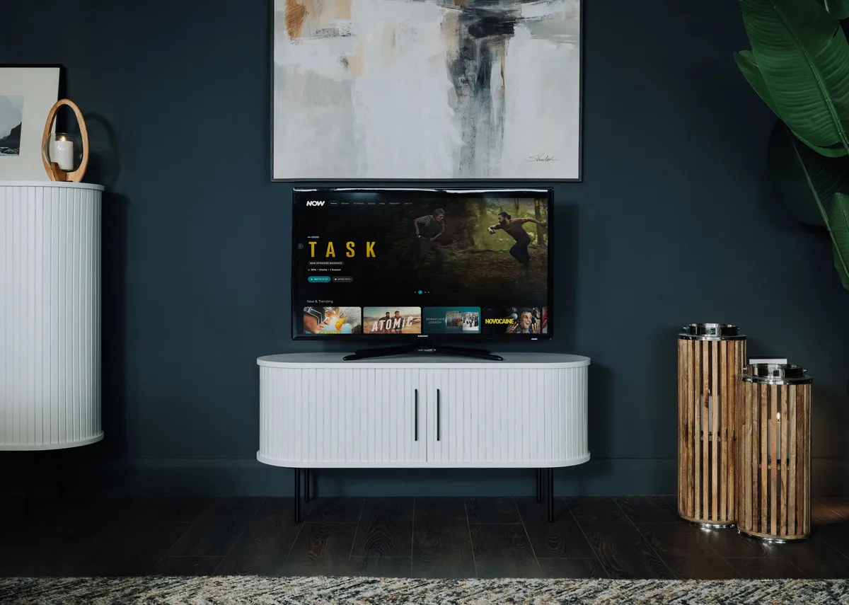 A lifestyle image of the Nola white tv unit with doors closed with Integrity canvas.