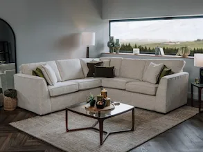 A lifetsyle image of the Carraroe corner sofa with Atrium coffee table and lamp table