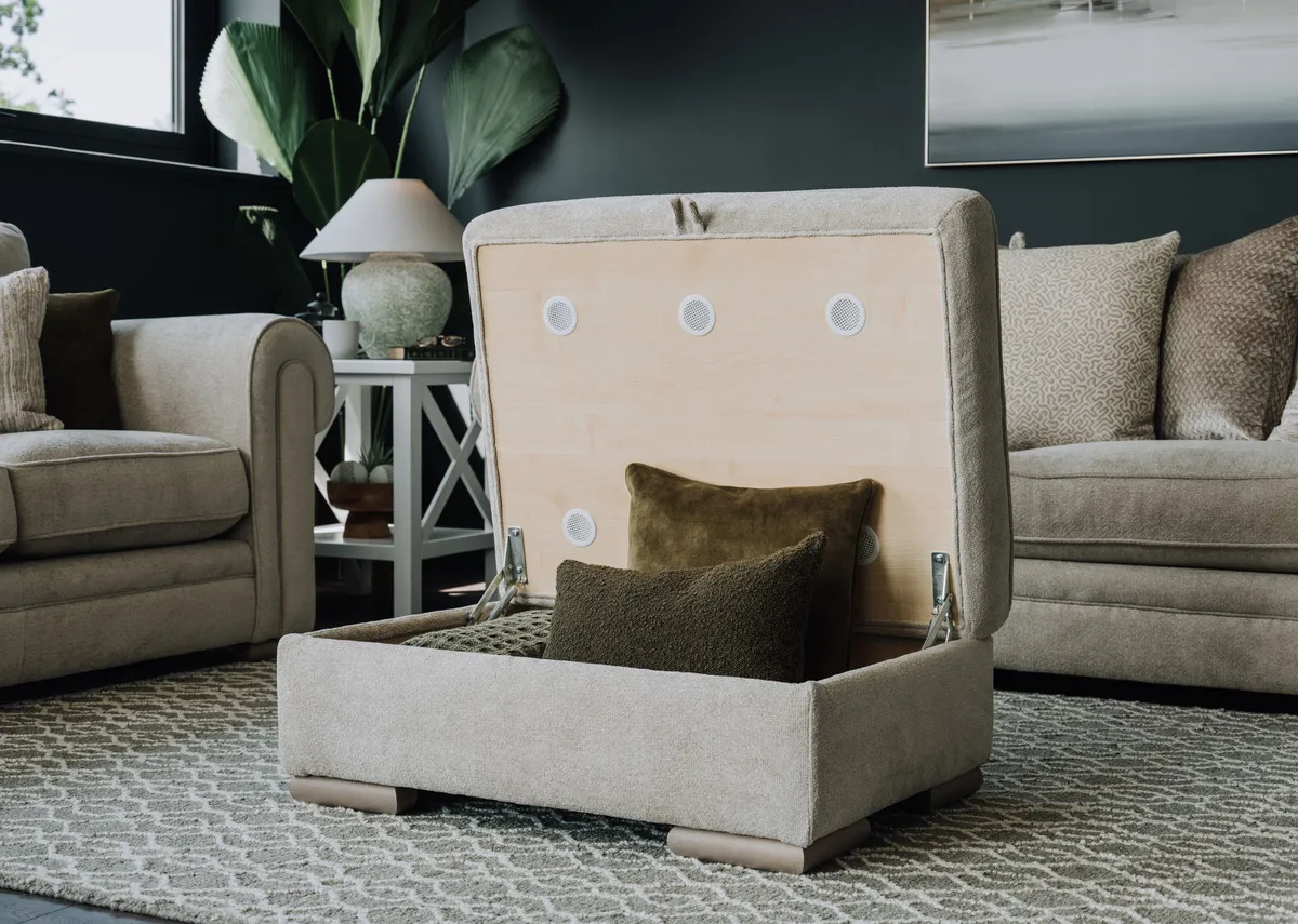 A lifestyle image of the Olivia footstool with lid lifted and storage for cushions.