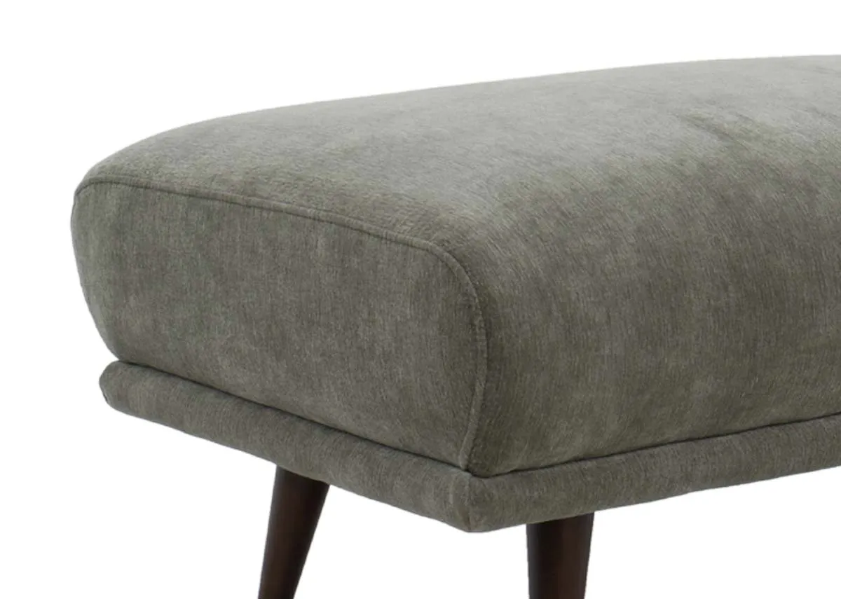 Cuddler armchair in rust colored fabric viewed from a slight right angle showing the armrests and deep seat.