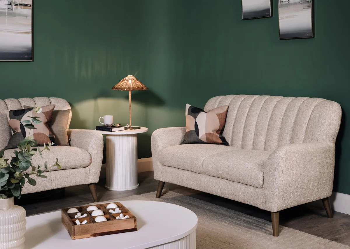 A lifetsyle image of the Harper 2 seater sofa with the Nola white lamp table with the Glenveagh lamp