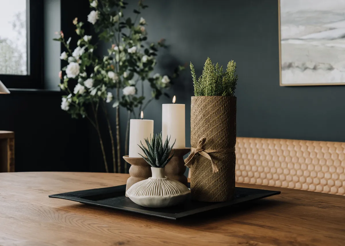 A lifetsyle image of the Atrani candle holders with Hibiscis vase on a black tray.