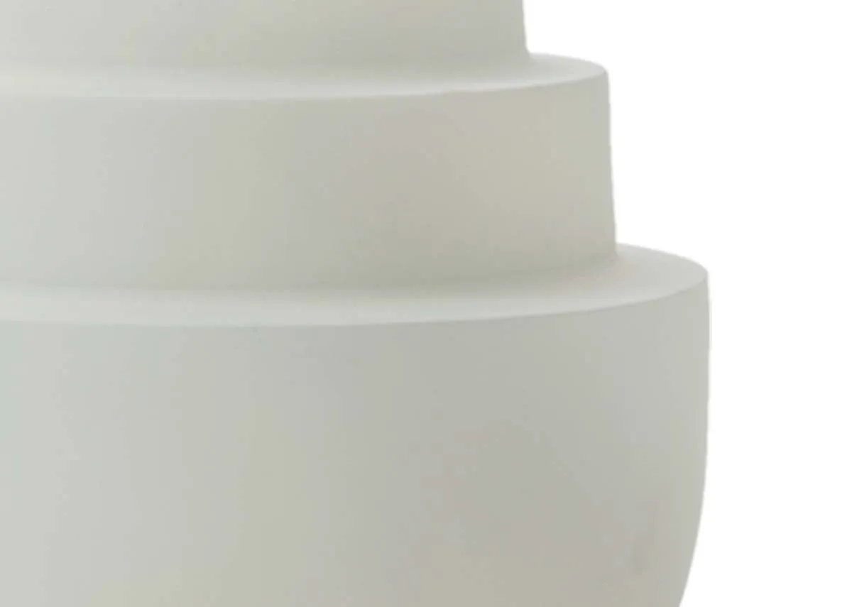 A close up detail of the concentric tiered sections of a matt cream tealight holder.