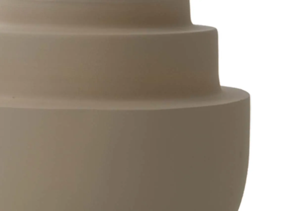 A close up detail of the concentric tiered sections of a large matt sand colored tealight holder.
