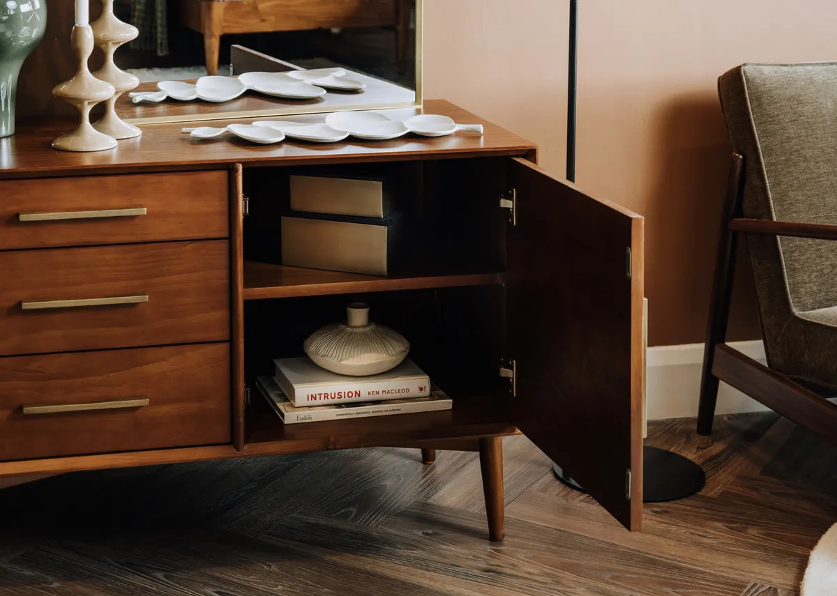 A lifestyle image of the Leya sideboard with the door open showing internal storage.