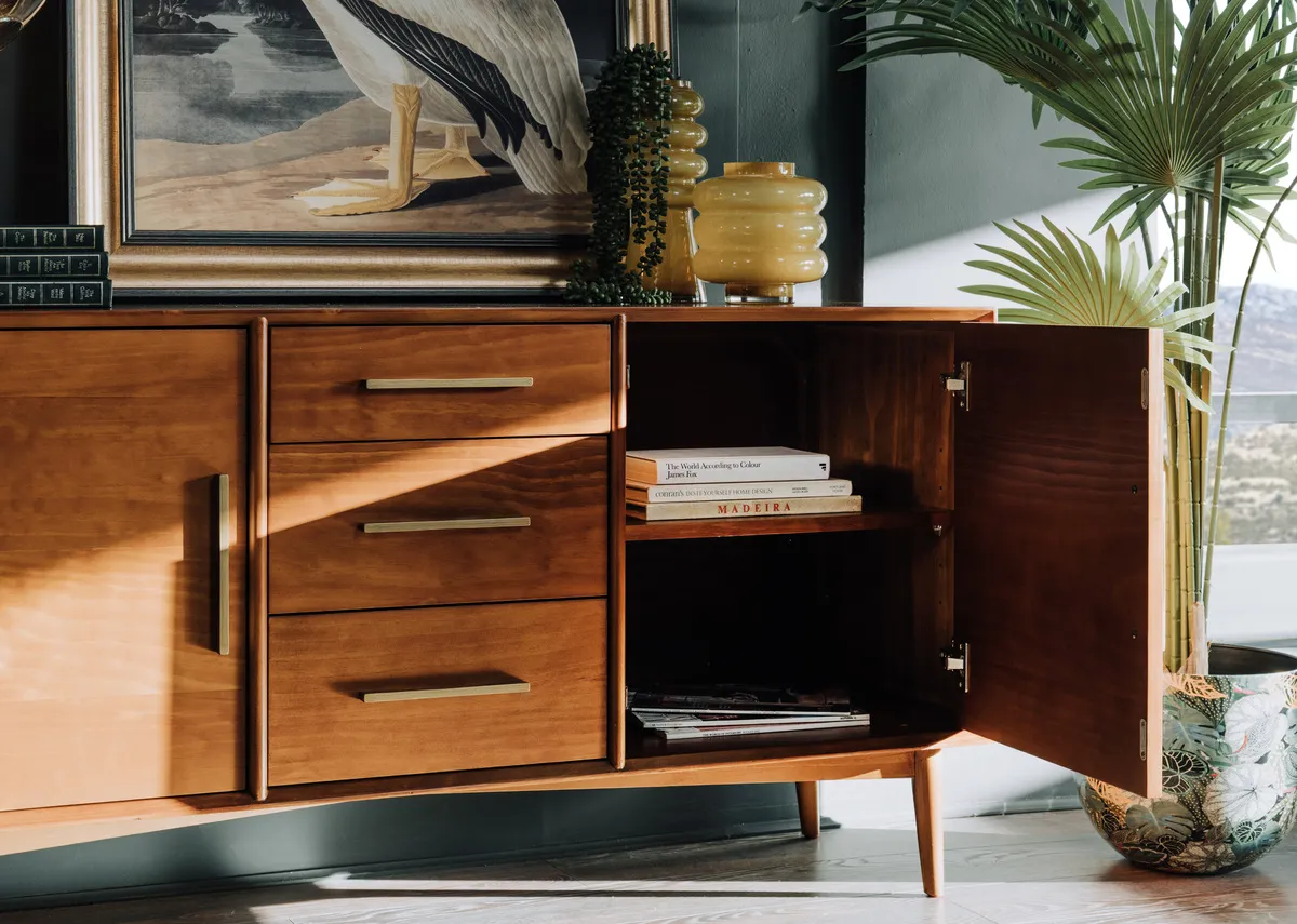 A lifestyle image of the Leya sideboard with door open showing internal storage.