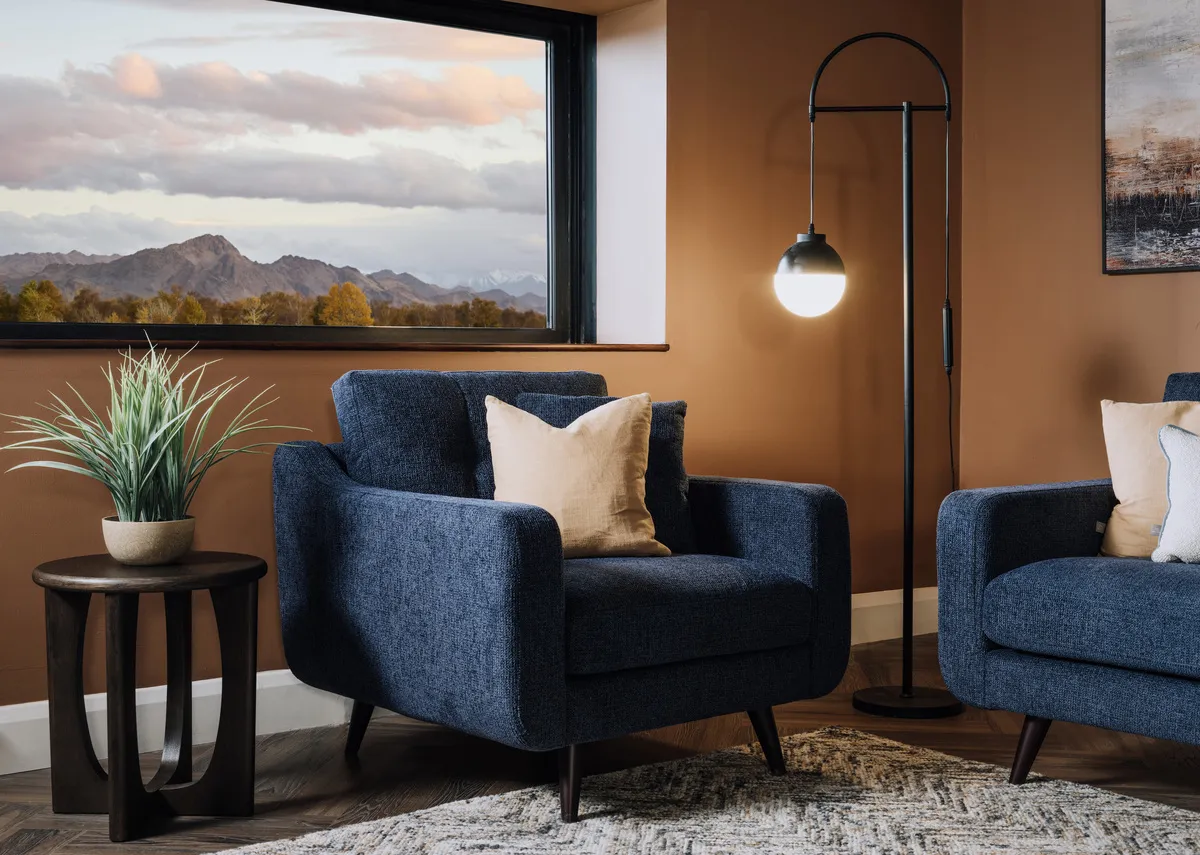 A lifestyle image of the Bandon armchair with sofa and Cameo lamp table with Casper lamp.