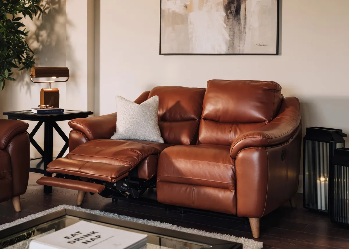A lifestyle image of the Blaze 2 sesater sofa reclined with Hampton black tables and Integrity canvas.