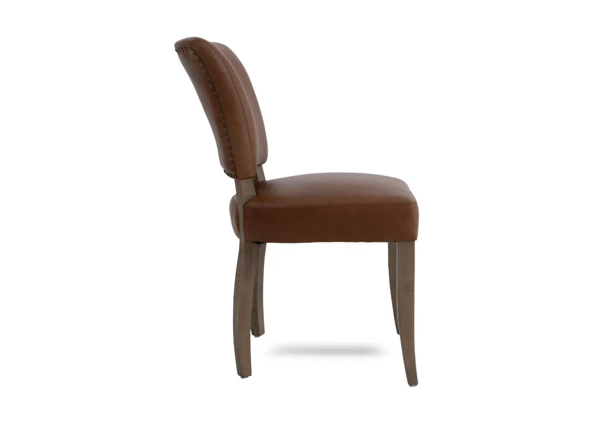 A tan leather dining chair from EZ Livings Geneva range. Side view of ash wood legs and frame.
