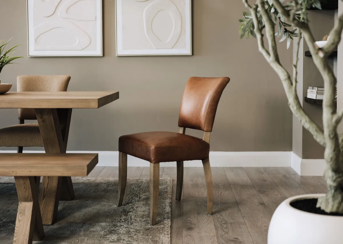 A lifestyle image of the Geneva leather chair with dining table and Gateway pictures