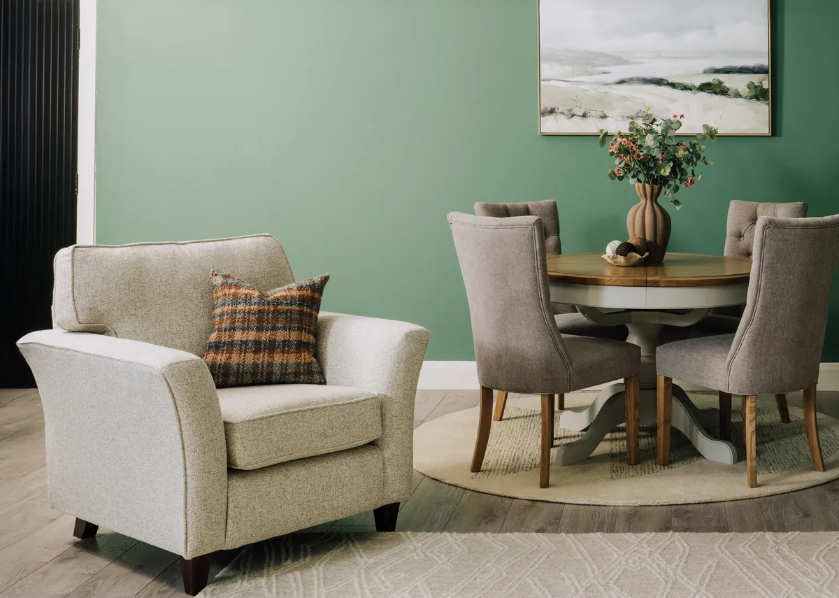 A lifetsyle image of the Kilronan armchair with Uilleann blue cushion with Georgia table and chairs.