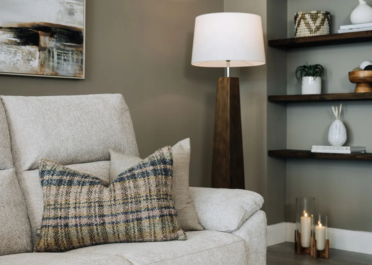 A lifestyle image of the Uilleann cushion on the Ashbrook sofa with the Fauna floor lamp.