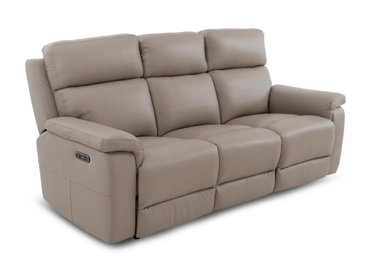 A 3 seater leather power reclining sofa in a fixed position from EZ Livings Raven range. Angled view of sofa in a light taupe.