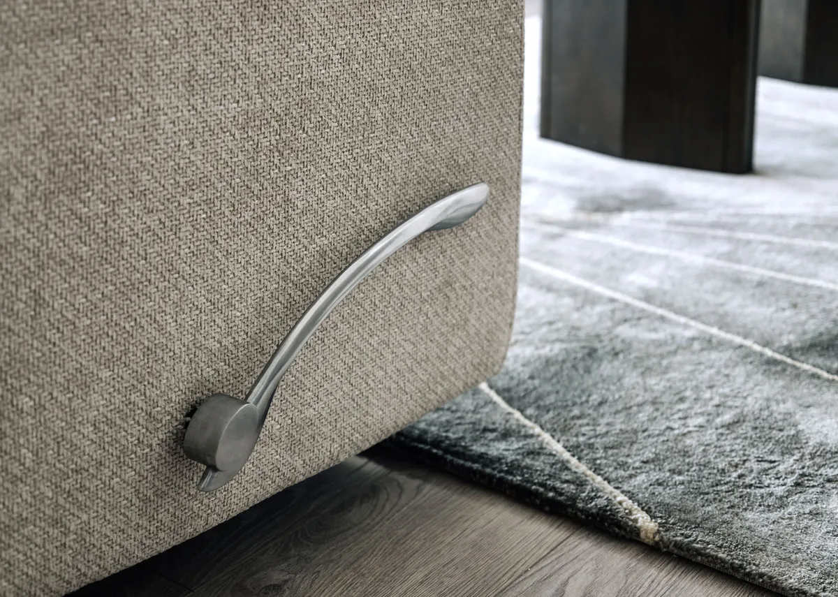 A lifestyle image of the Annalee beige recliner with a closeup on the manual lever.