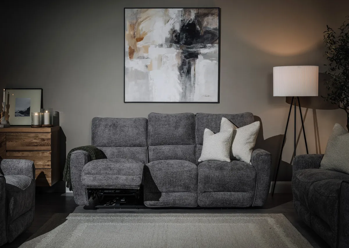 A lifestyle image of the Ashbrook 3  seater recliner sofa with Evocative print with Lura lamp.