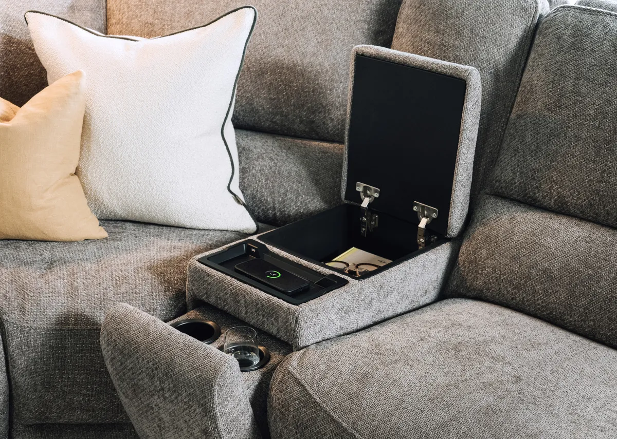 A lifestyle image of the Ashbrook sofa drinks holder with armrest up.