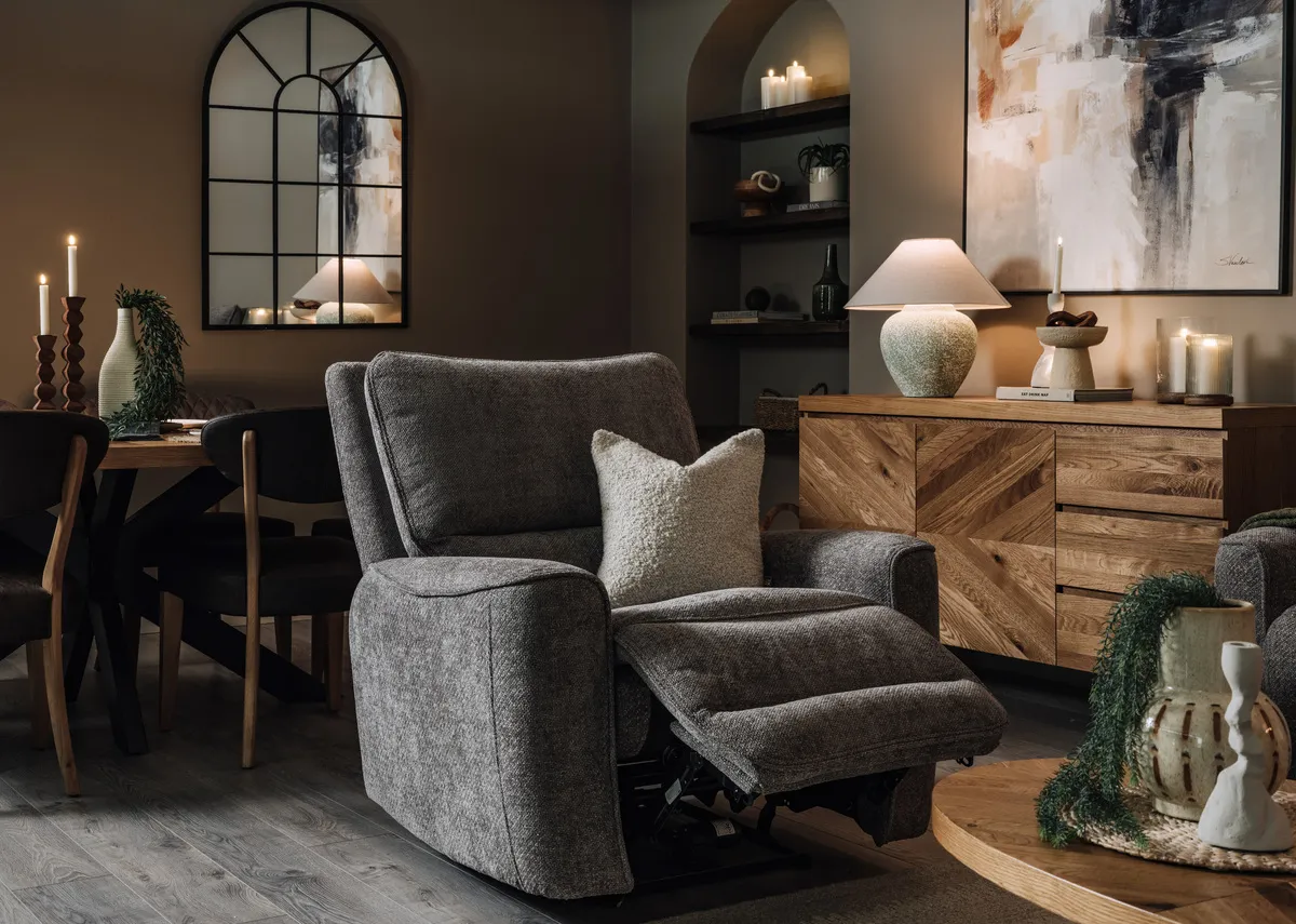 A lifestyle image of the Ashbrook reclined with the Ellipse coffee table and sideboard.