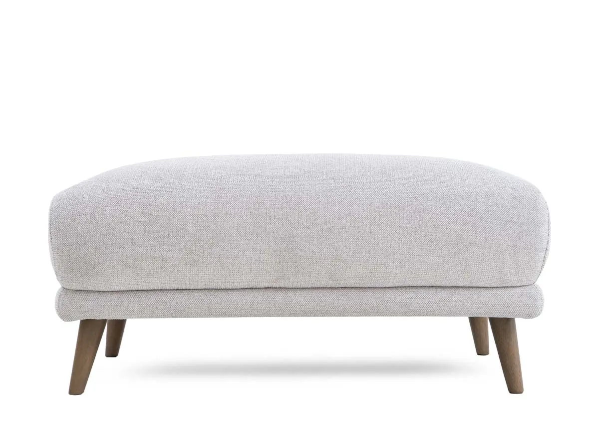 A padded footstool in a light stone fabric from EZ Livings Legend range. Front view
