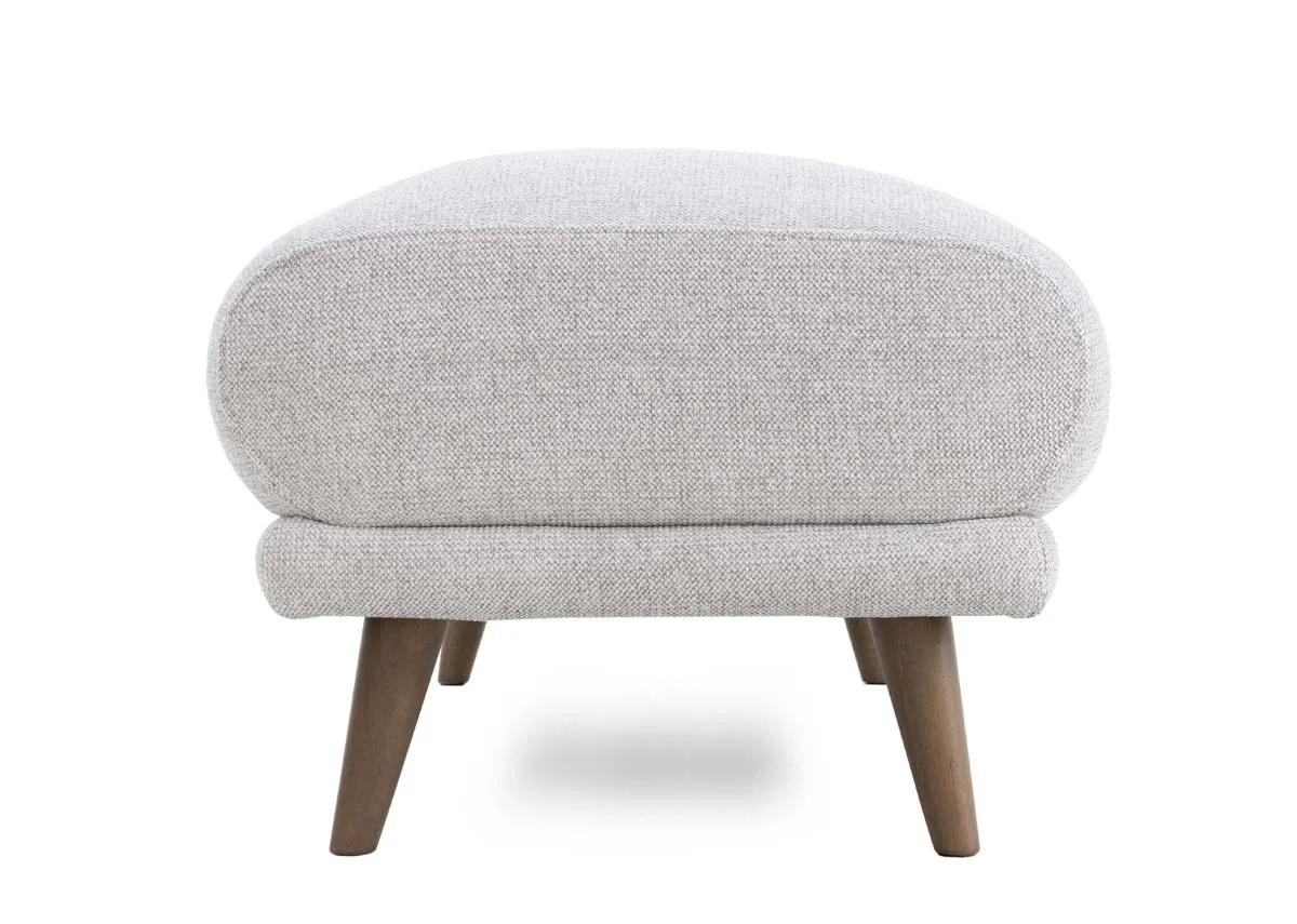 A padded footstool in a light stone fabric from EZ Livings Legend range. Side view