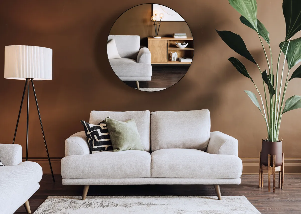 A lifestyle image of the Legend 2 seater sofa with Elling mirror and Starlette lamp.