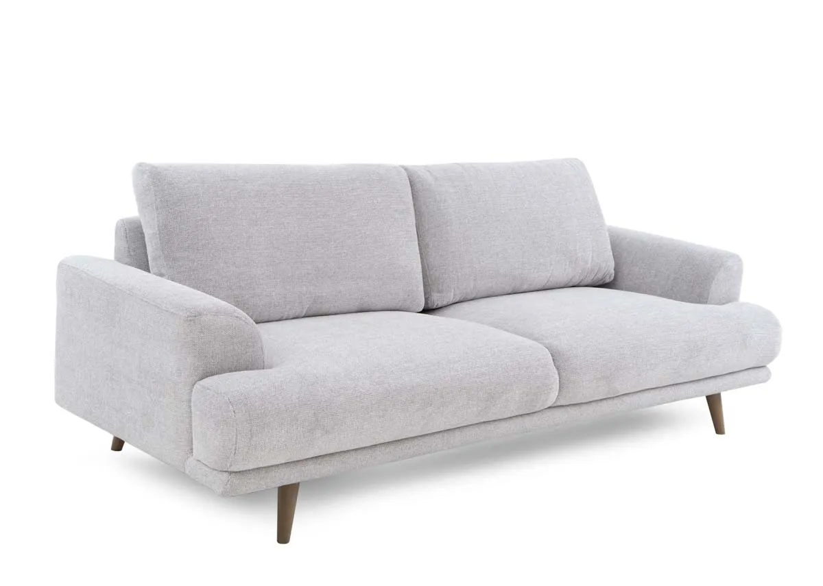A 3 seater fabric sofa from EZ Livings Legend Range with an angled view of wide frame and soft grey upholstery.