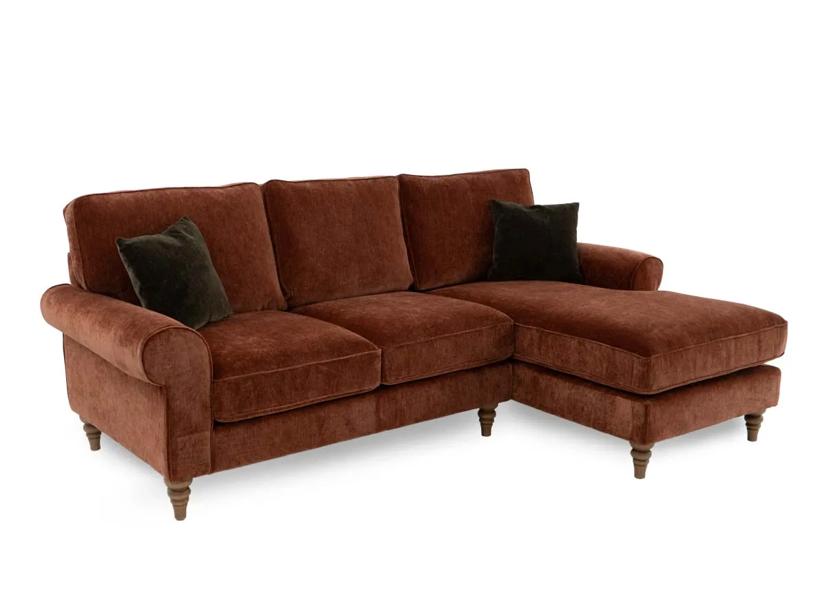 A rust fabric corner sofa from EZ Livings Cotswold range. Angled view of sofa with 2 green cushions.
