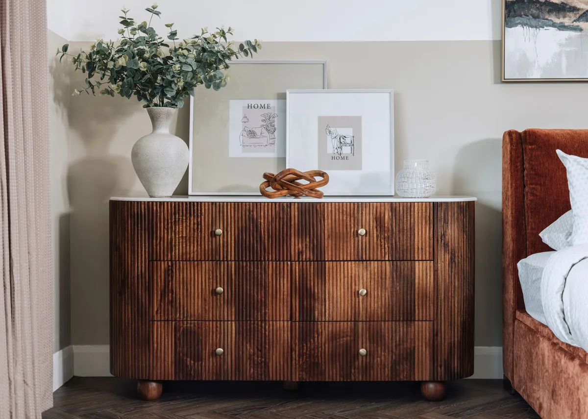 A lifestyle image of the Bunton dresser with a vase and a selection of picture frames