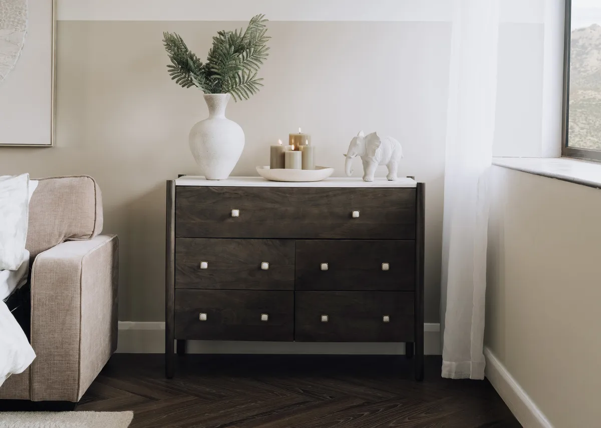 A lifestyle image of the Nora chest with Nevada sofabed with vase and a selection of accessories.