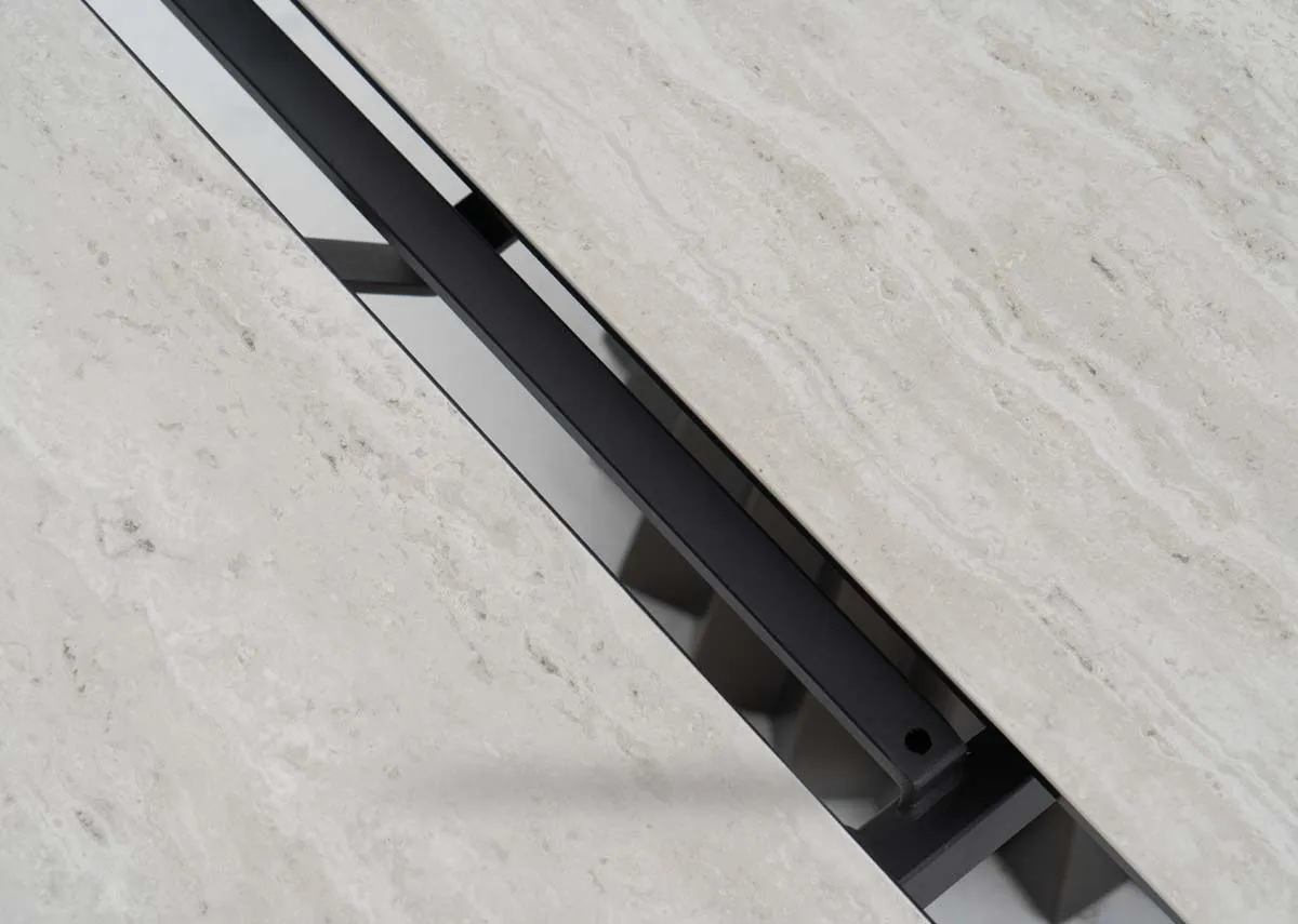 A dark metal dining table with round cermic table top from EZ Livings Zenith range. Closeup of revolving middle extension piece.