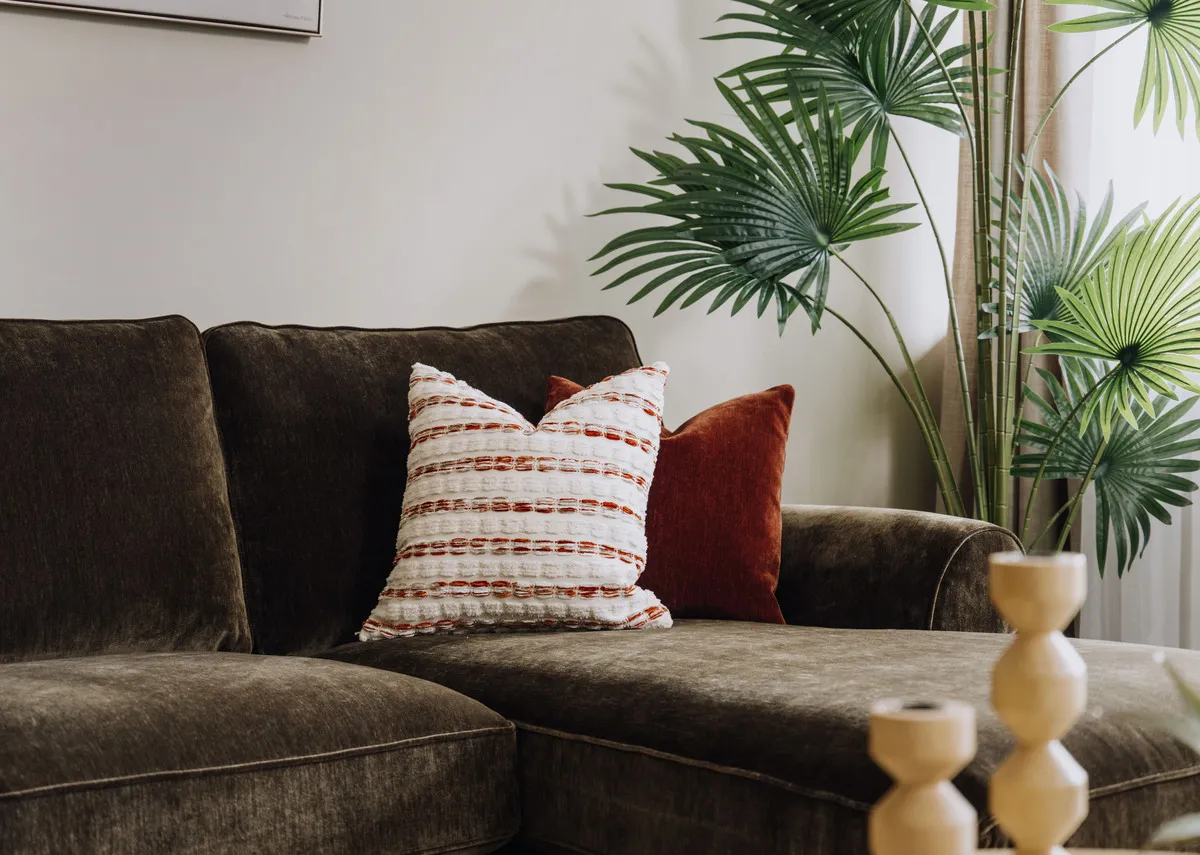 A lifestyle image of the Rustic field cushion with the Cotswold chaise in green.