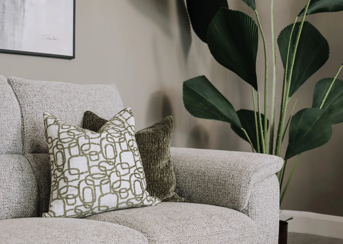 A lifestyle image of the Spriuce Trails and Rushtic Field cushions on a Savoy sofa.