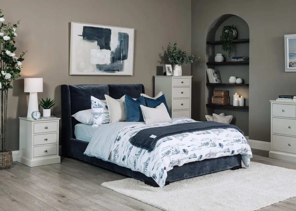 A lifestyle image of the Comfy blue bedframe with Foxford toile duvet set and Riverdale locker and chests.