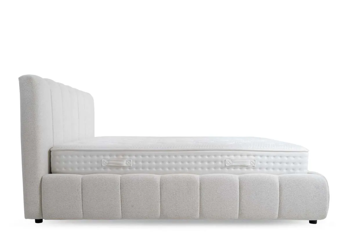 A cream fabric 5ft bedframe from EZ Livings Julia range. Side view of panel design and black feet.