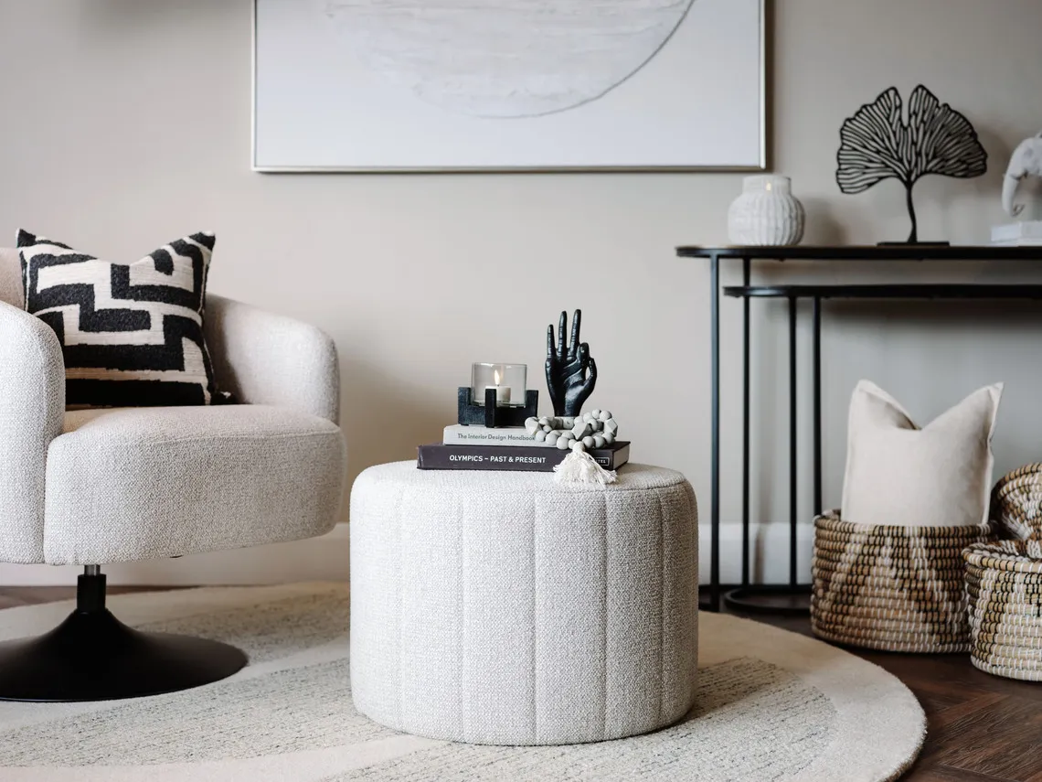 A lifestyle image of the Alexo pouffee with the Fusion swivel with a selection of accessories from EZ Living Furniture.
