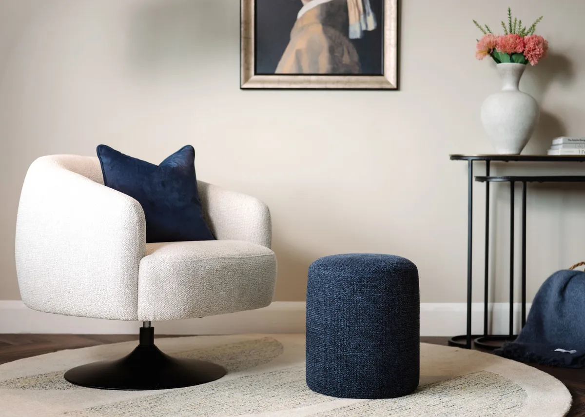 A lifestyle image of the Parker navy footstool with Girl in a Pearl Earring picture and Swivel 