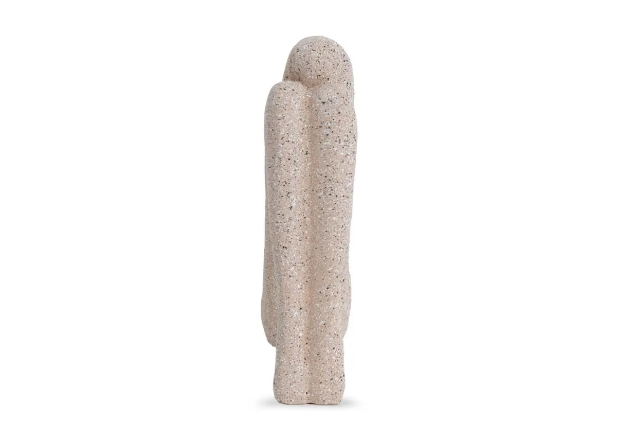 A beige stone human ornament of a head resting on knees pose.Front view