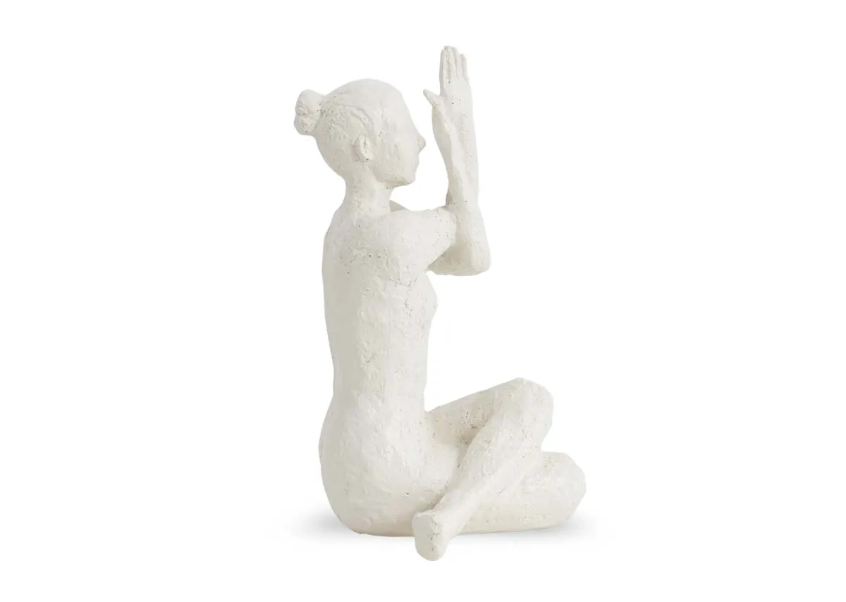 A white ornament shows a femalein a yoga pose.Side view