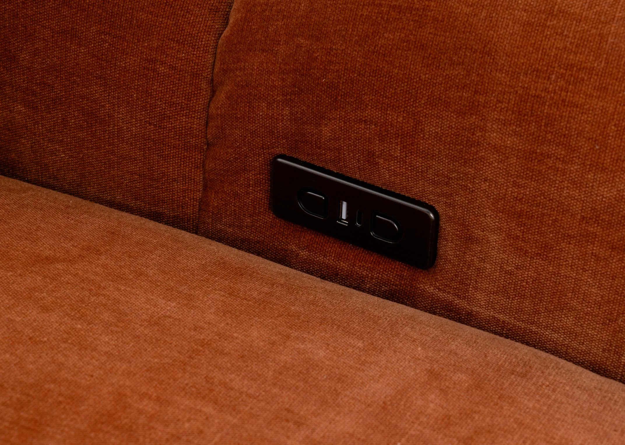 A rust orange 2 seater sofa from EZ Livings Eleanor range. Closeup of button and usb charging point on inside of arm on both sides.