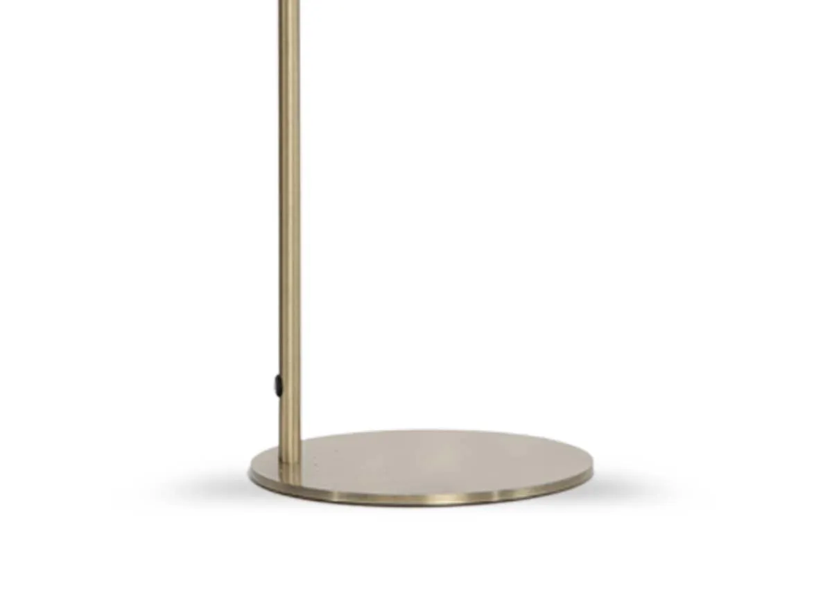 A gold table lamp with a smokey grey glass shade from EZ Livings Alisha. Closeup of inline cable switch