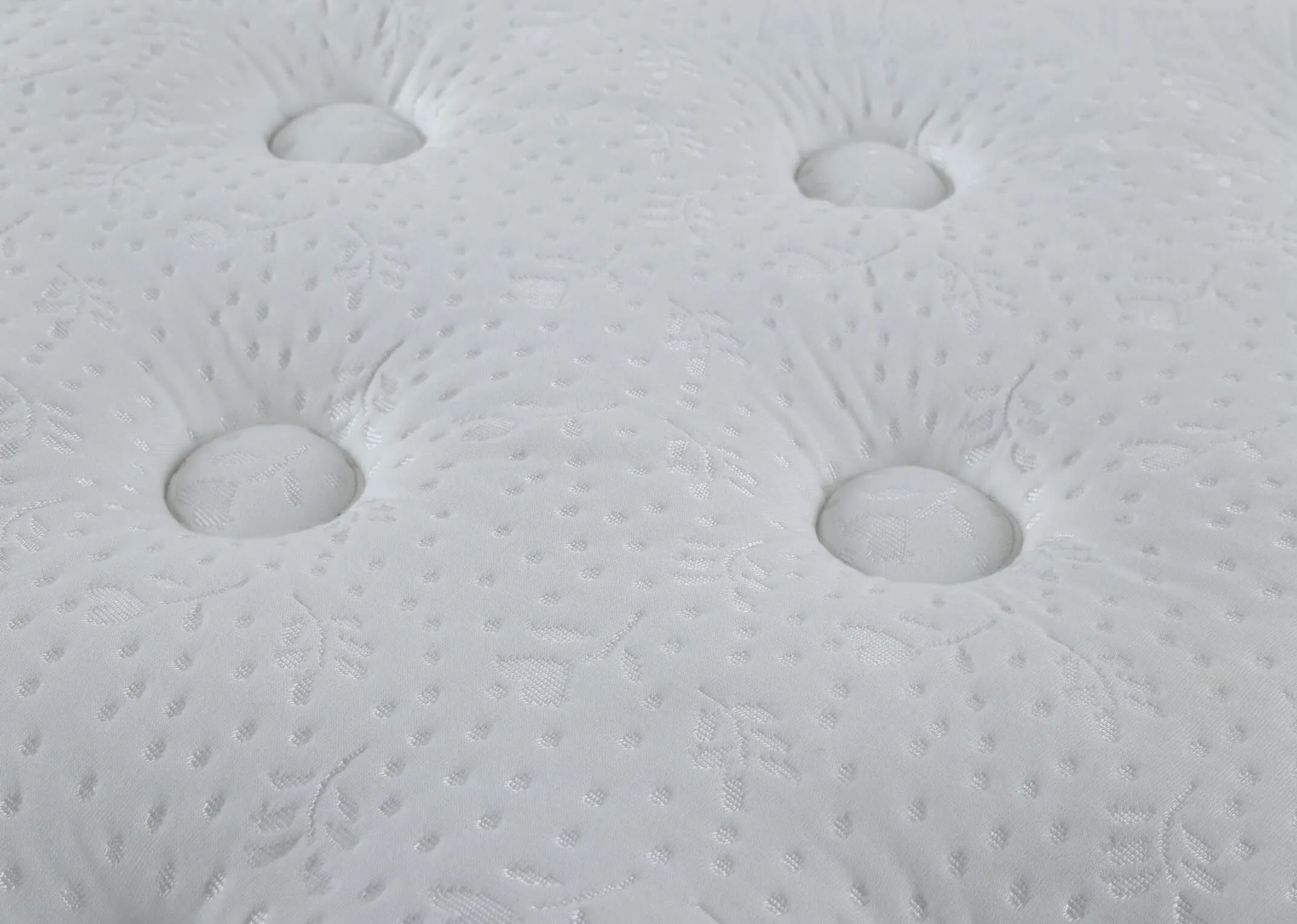 A lifestyle shot of the Emilys Dream 5 foot king size mattress on a bed frame with duvet.