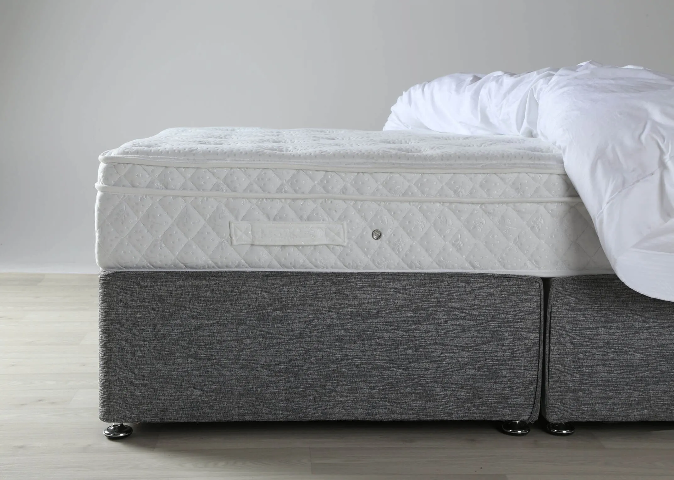 A lifestyle shot of the Emilys Dream 5 foot king size mattress on a bed frame with duvet.