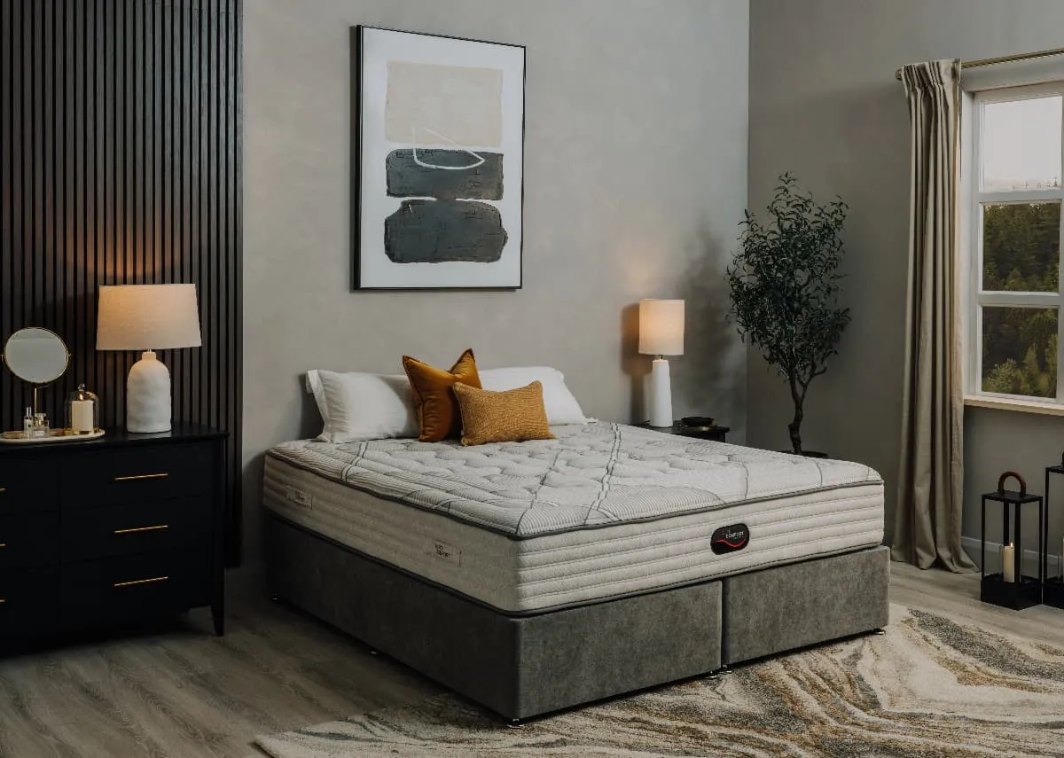 A lifetsyle image of the Elite Comfort mattress on a grey bed base with chevron chest and Mode Canvas.