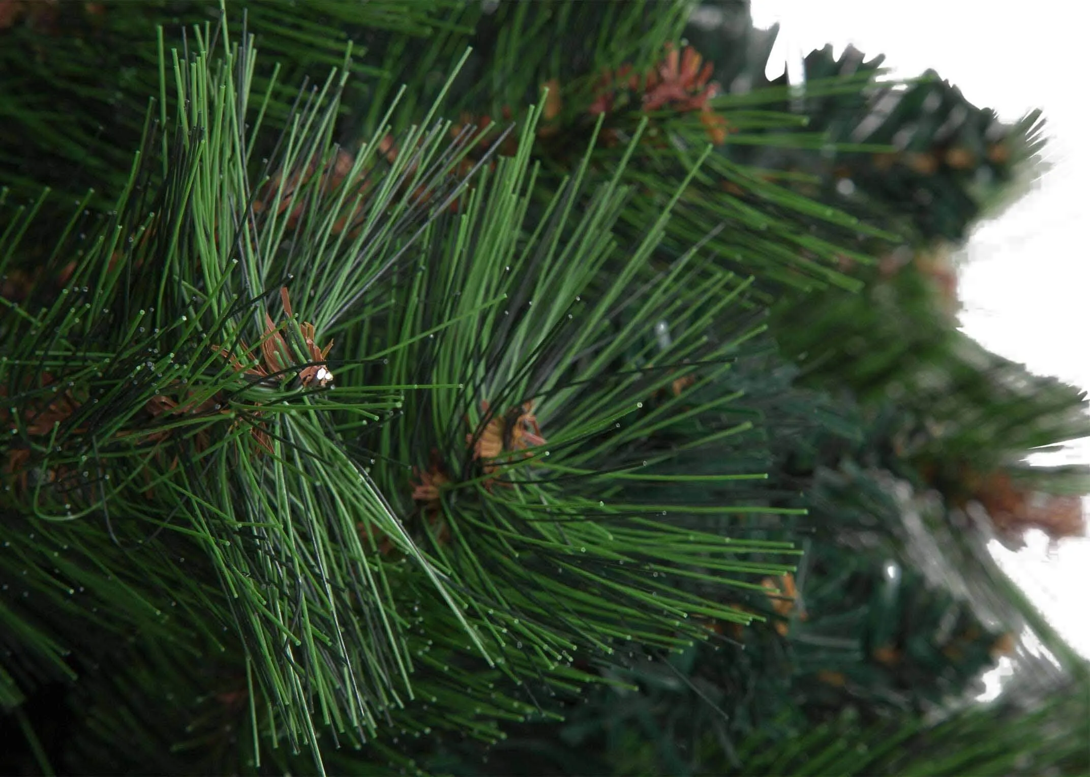 A close up of the needles on a branch of the 180cm pine Christmas tree highlighting the faux material.