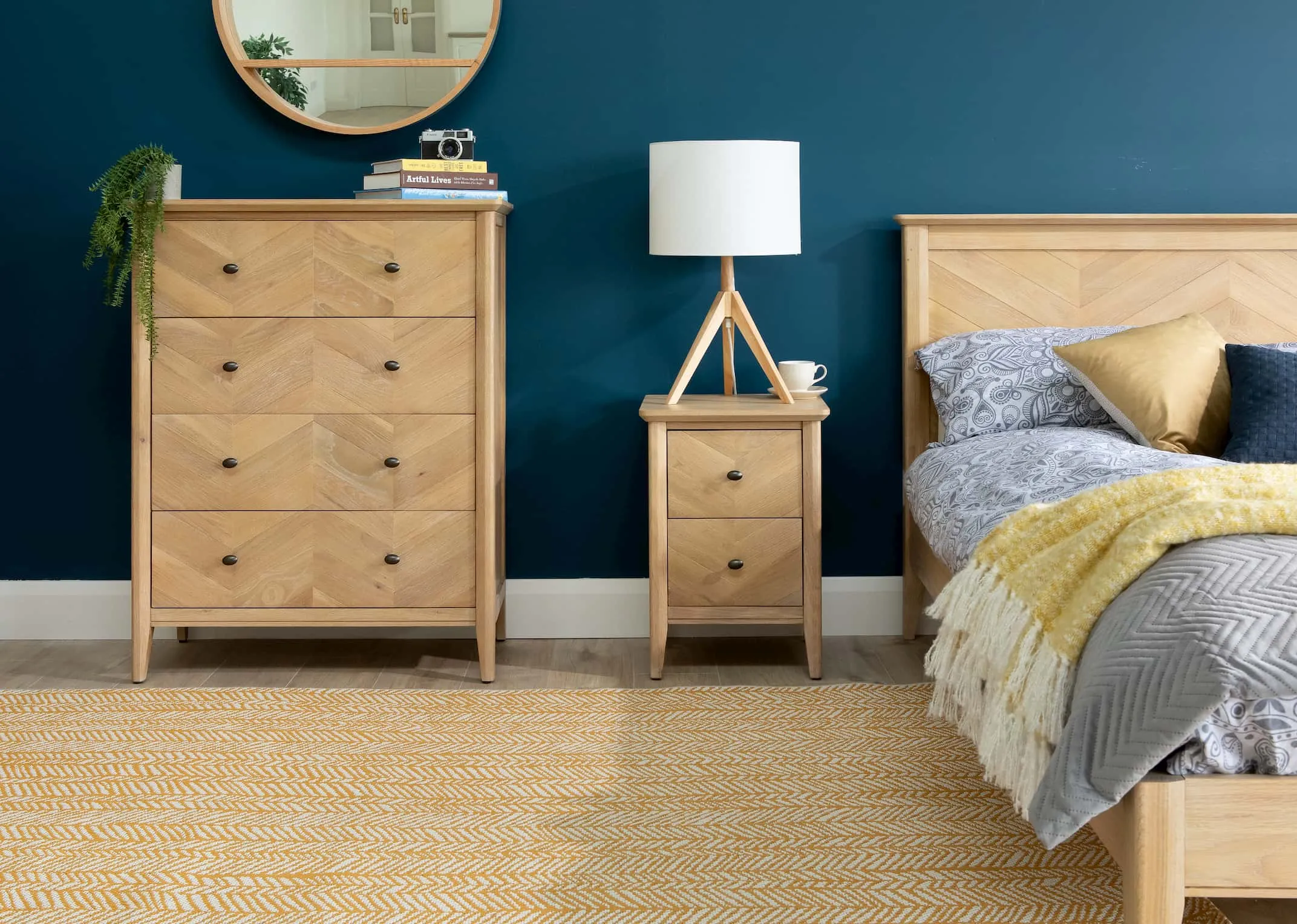 A lifestyle image of the Herringbone Bedroom range including the 4 drawer chest with Akira lamp & scandi yellow rug.