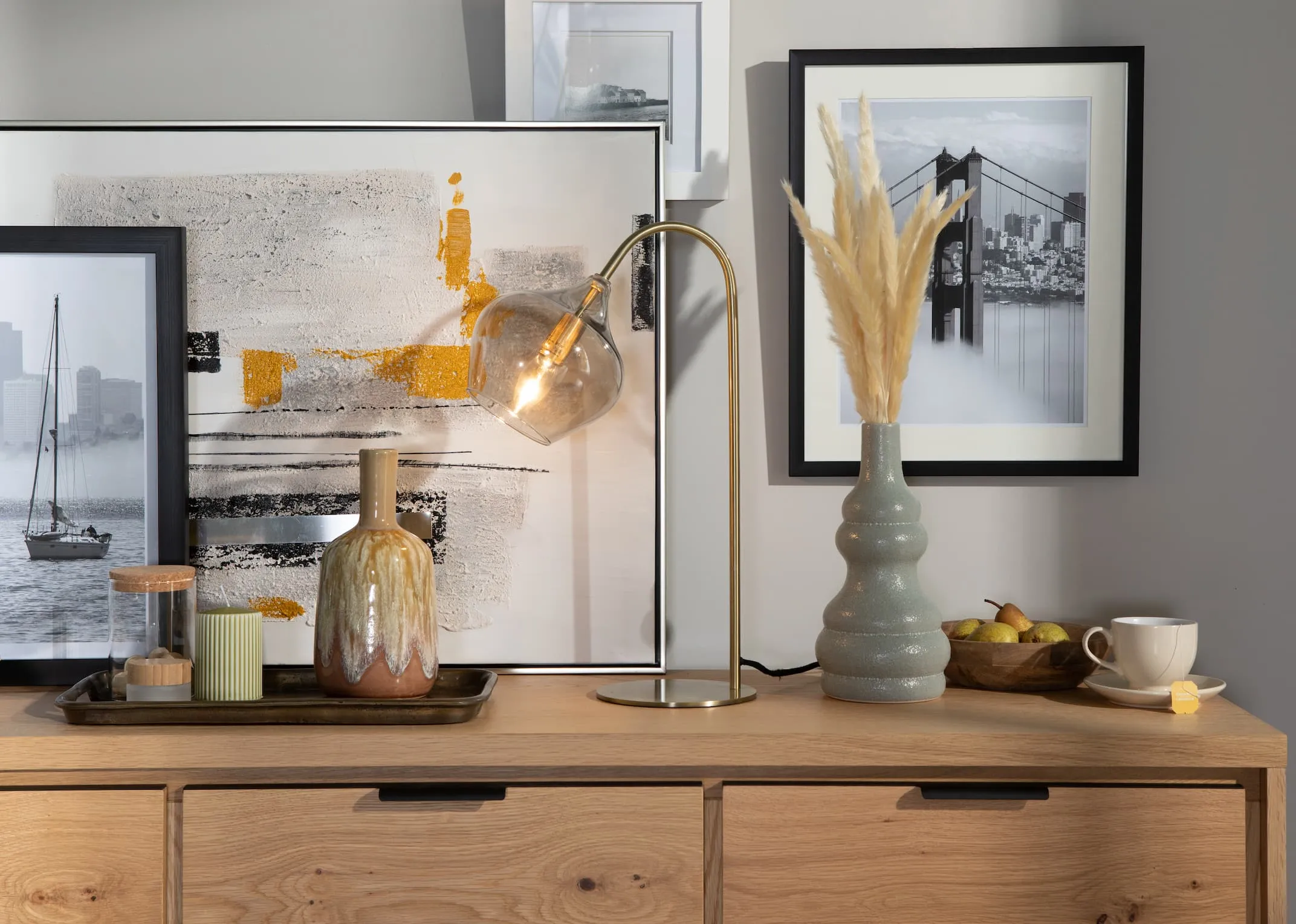 A lifestyle image of the Rakel lamp on with Livorno Sideboard and a selection of art